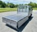 White double cab truck with an open cargo bed viewed from the rear